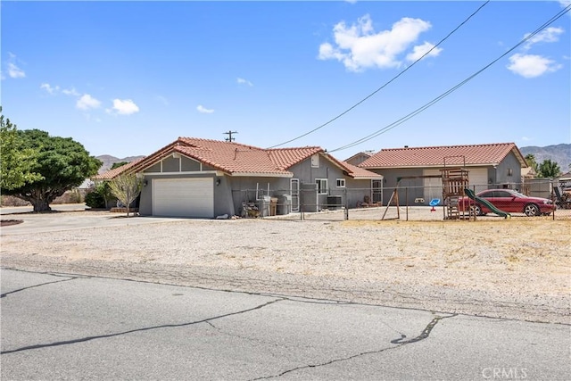 18043 Preston St, Hesperia, CA 92345 - ranch-style house with a tile roof, stucco siding, concrete driveway, a garage, and a playground
