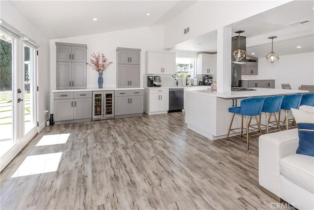 16652 Itasca St, Northridge, CA 91343 - kitchen with beverage cooler, vaulted ceiling, gray cabinetry, ventilation hood, and stainless steel appliances