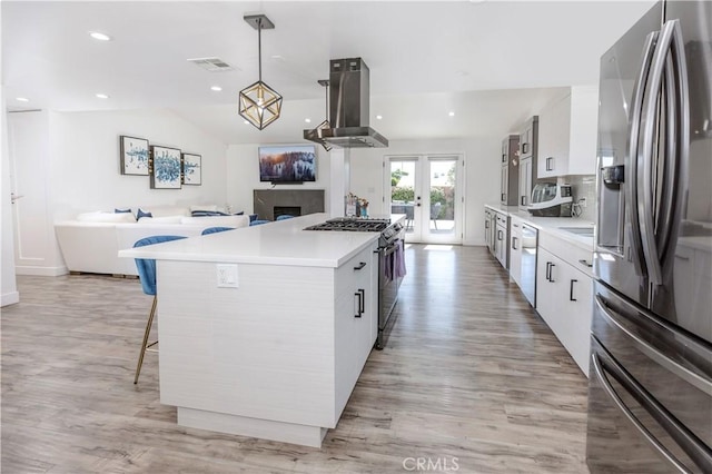 16652 Itasca St, Northridge, CA 91343 - kitchen featuring appliances with stainless steel finishes, extractor fan, a kitchen breakfast bar, a kitchen island, and white cabinetry