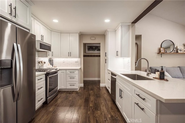 26616 Balerna Dr, Saugus, CA 91350 - kitchen with appliances with stainless steel finishes, light countertops, a peninsula, tasteful backsplash, and dark wood finished floors