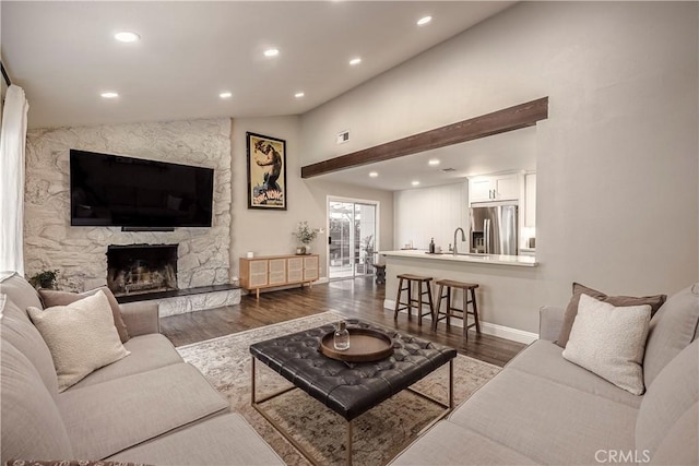 26616 Balerna Dr, Saugus, CA 91350 - living area featuring lofted ceiling, dark wood-style flooring, recessed lighting, and a stone fireplace