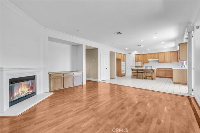 16461 Medinah St, Fontana, CA 92336 - unfurnished living room featuring light wood-style floors, ornamental molding, a glass covered fireplace, and recessed lighting