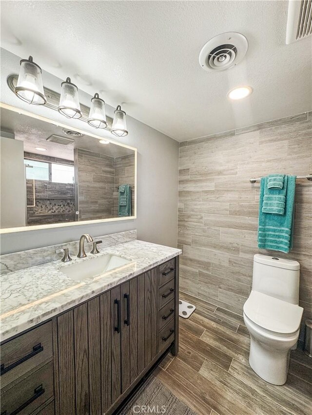 741 Ocotillo Rd, Blythe, CA 92225 - bathroom featuring vanity, wood finished floors, tile walls, and a textured ceiling