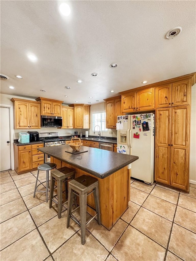 741 Ocotillo Rd, Blythe, CA 92225 - kitchen with appliances with stainless steel finishes, recessed lighting, dark countertops, a center island, and a breakfast bar