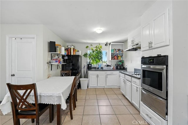 711 E 118th St, Los Angeles, CA 90059 - kitchen featuring stainless steel oven, a warming drawer, white cabinetry, under cabinet range hood, and dark countertops