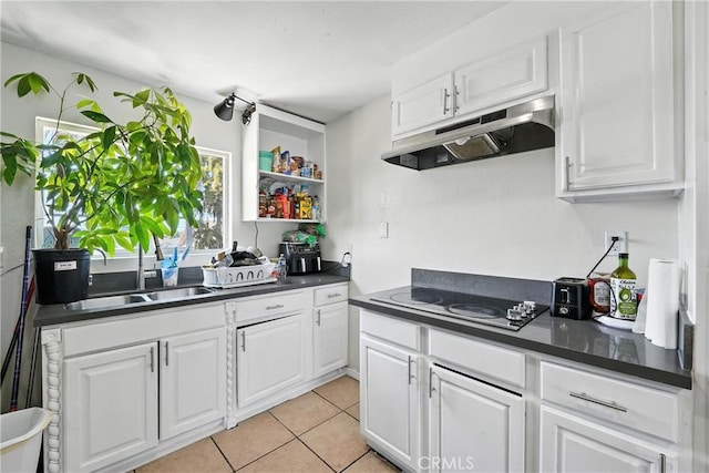 711 E 118th St, Los Angeles, CA 90059 - kitchen featuring under cabinet range hood, black electric cooktop, dark countertops, and white cabinets