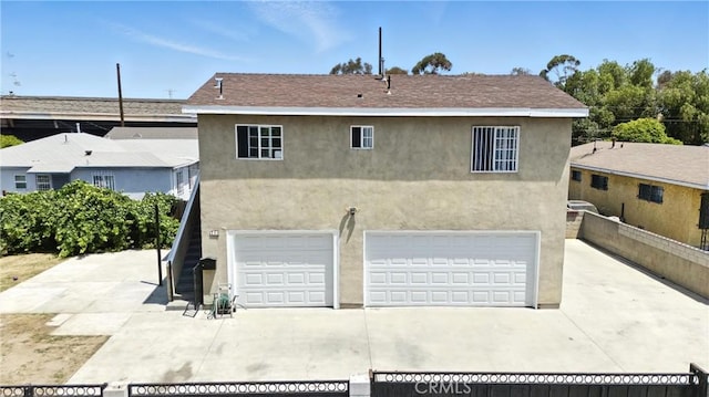711 E 118th St, Los Angeles, CA 90059 - view of front facade with stucco siding, a garage, stairway, and driveway
