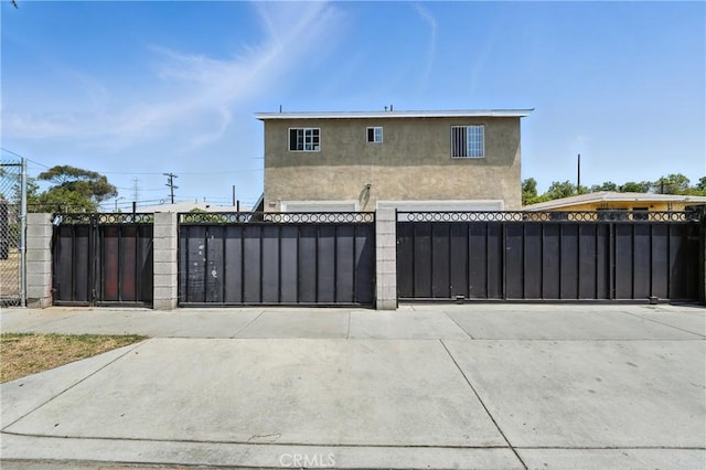 711 E 118th St, Los Angeles, CA 90059 - view of front of home with stucco siding, a fenced front yard, and a gate