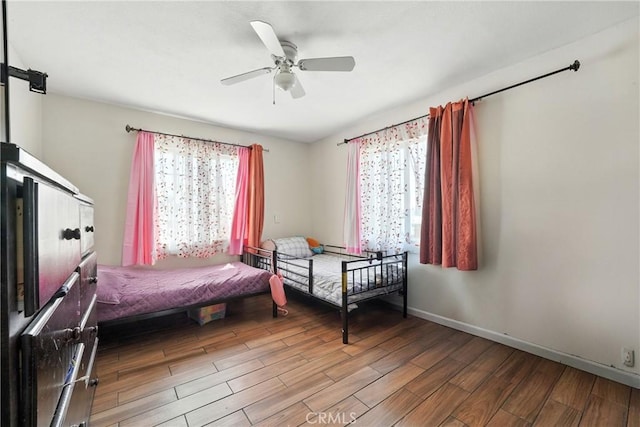 711 E 118th St, Los Angeles, CA 90059 - bedroom with multiple windows, wood finished floors, and ceiling fan