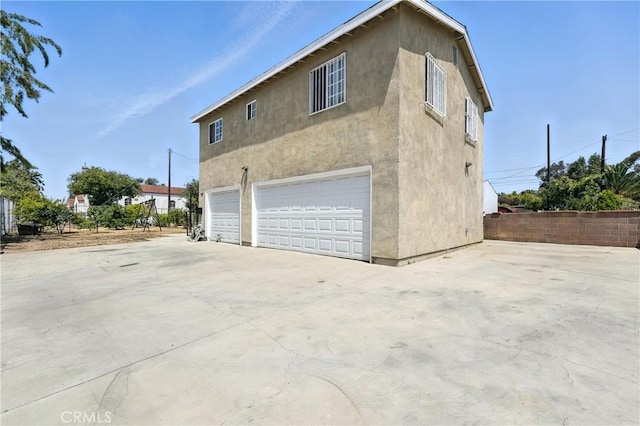 711 E 118th St, Los Angeles, CA 90059 - view of home's exterior with stucco siding and a garage