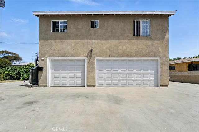 711 E 118th St, Los Angeles, CA 90059 - view of front of house with stucco siding, an attached garage, and driveway