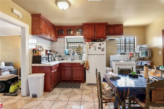 2734 S Redondo Blvd, Los Angeles, CA 90016 - kitchen featuring white appliances, tile countertops, under cabinet range hood, tasteful backsplash, and light tile patterned floors