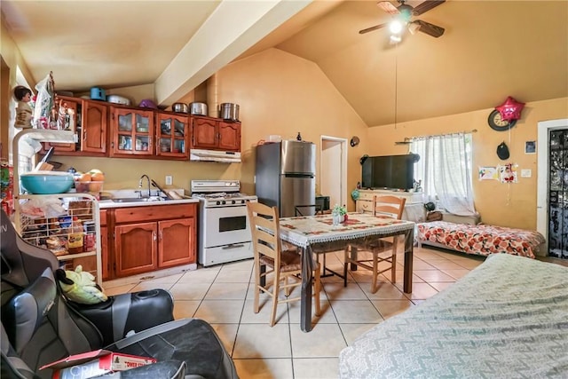2734 S Redondo Blvd, Los Angeles, CA 90016 - kitchen featuring white gas range oven, under cabinet range hood, freestanding refrigerator, vaulted ceiling, and light tile patterned flooring