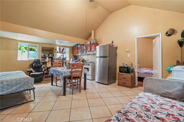 2734 S Redondo Blvd, Los Angeles, CA 90016 - kitchen with freestanding refrigerator, white range with gas stovetop, light tile patterned flooring, black microwave, and lofted ceiling