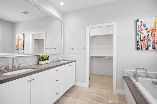 152 Plum Lily, Irvine, CA 92618 - bathroom featuring double vanity, tasteful backsplash, wood finished floors, a bath, and recessed lighting