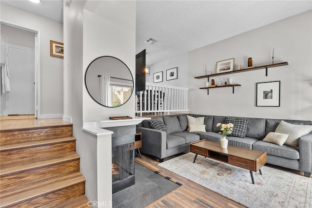 17910 River Cir Unit 1, Canyon Country, CA 91387 - living area with a textured ceiling, wood finished floors, stairway, and a tile fireplace