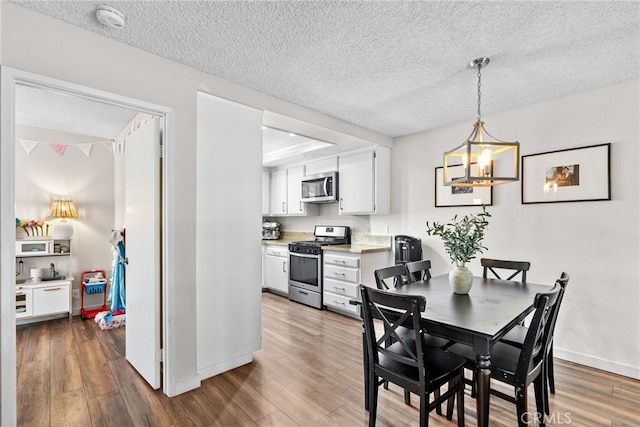 17910 River Cir Unit 1, Canyon Country, CA 91387 - dining area featuring a textured ceiling, wood finished floors, and a chandelier