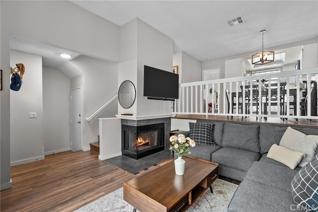 17910 River Cir Unit 1, Canyon Country, CA 91387 - living room featuring wood finished floors, a tile fireplace, stairway, and a textured ceiling