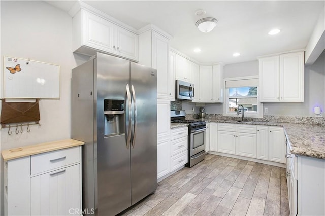 429 S Colfax St, La Habra, CA 90631 - kitchen with stainless steel appliances, light wood-type flooring, white cabinetry, light stone countertops, and recessed lighting