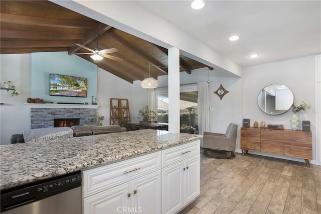 429 S Colfax St, La Habra, CA 90631 - kitchen featuring stainless steel dishwasher, light wood-style floors, white cabinets, light stone counters, and a warm lit fireplace