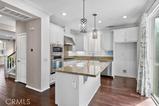 252 W Tulip Tree Ave, Orange, CA 92865 - kitchen featuring appliances with stainless steel finishes, range hood, dark wood-style floors, white cabinets, and recessed lighting