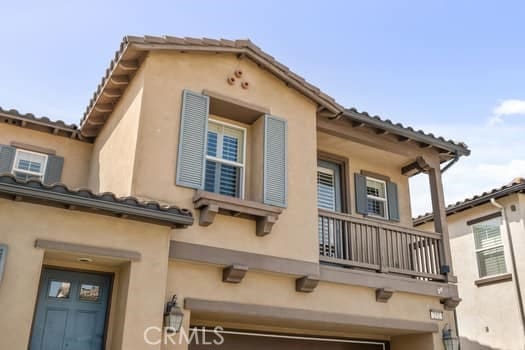 252 W Tulip Tree Ave, Orange, CA 92865 - view of side of home featuring a balcony, stucco siding, a garage, and a tiled roof