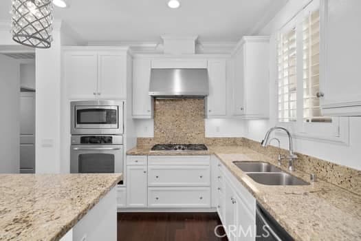 252 W Tulip Tree Ave, Orange, CA 92865 - kitchen featuring appliances with stainless steel finishes, exhaust hood, white cabinets, light stone counters, and recessed lighting