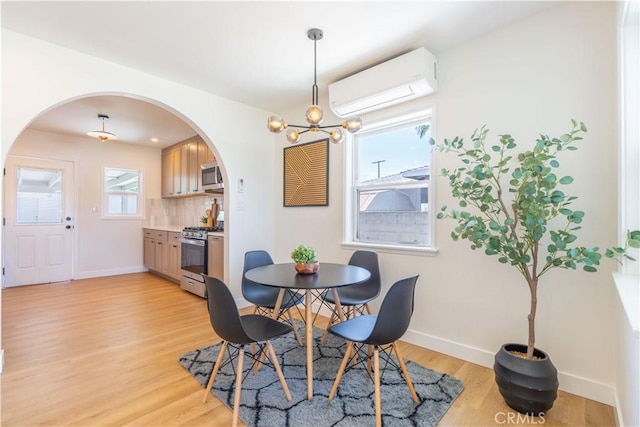 10536 La Mirada Blvd, Whittier, CA 90604 - dining space with a wall unit AC, arched walkways, light wood finished floors, and a chandelier