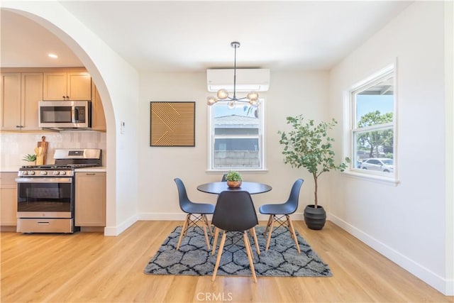 10536 La Mirada Blvd, Whittier, CA 90604 - dining space featuring light wood-style flooring, a wall mounted air conditioner, arched walkways, a chandelier, and recessed lighting