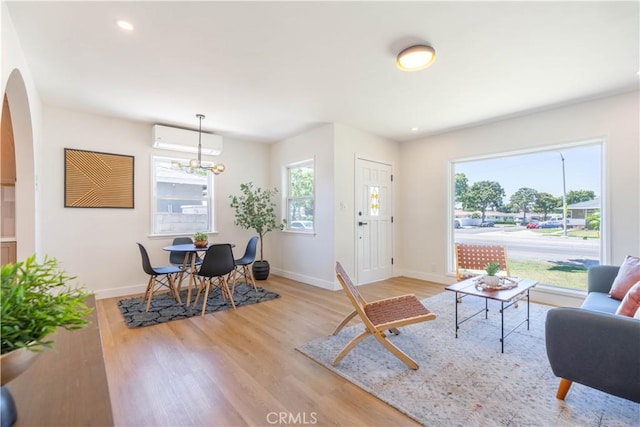 10536 La Mirada Blvd, Whittier, CA 90604 - living room featuring arched walkways, light wood-style flooring, a wall mounted air conditioner, a chandelier, and recessed lighting