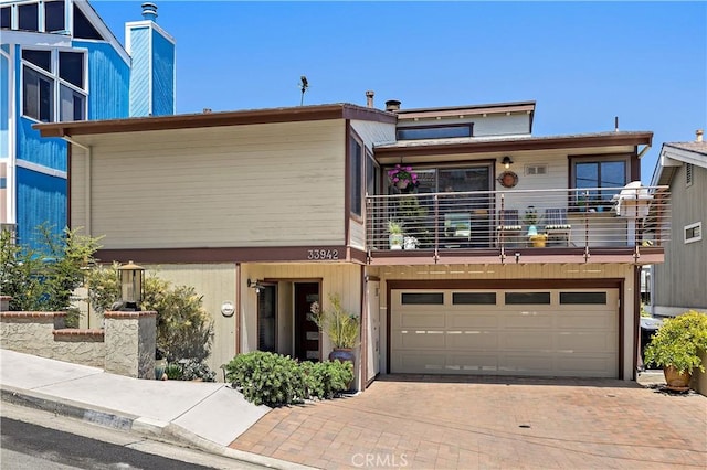 33942 Pequito Dr, Dana Point, CA 92629 - view of front of house featuring a balcony, decorative driveway, a garage, and a chimney