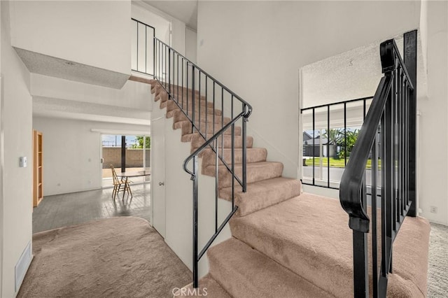 4510 E Hightree Cir, Anaheim, CA 92807 - staircase featuring carpet floors and a towering ceiling