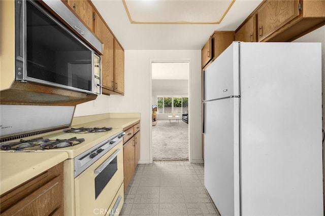 4510 E Hightree Cir, Anaheim, CA 92807 - kitchen featuring white appliances, light countertops, brown cabinetry, light colored carpet, and light flooring