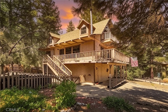 2229 Birchwood Way, Pine Mountain Club, CA 93222 - back of house at dusk with a balcony, a deck, a shingled roof, and stairs