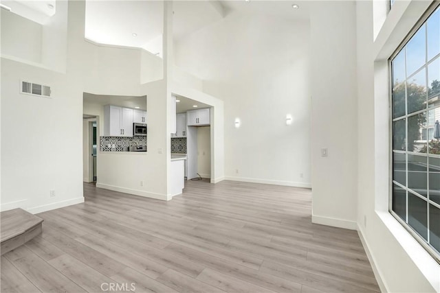 11150 Glenoaks Blvd Unit 106, Pacoima, CA 91331 - unfurnished living room with light wood-style flooring and a high ceiling