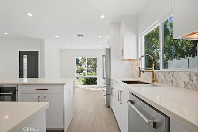 1230 Spazier Ave, Glendale, CA 91201 - kitchen featuring stainless steel appliances, white cabinets, light wood-type flooring, tasteful backsplash, and modern cabinets