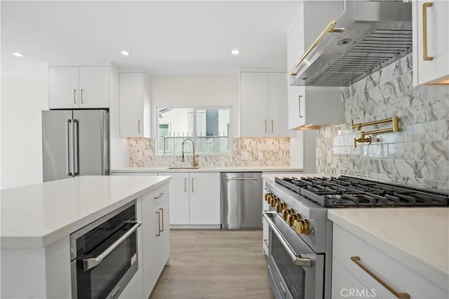 1230 Spazier Ave, Glendale, CA 91201 - kitchen with high end appliances, exhaust hood, decorative backsplash, white cabinets, and recessed lighting