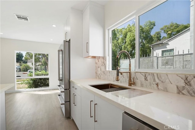 1230 Spazier Ave, Glendale, CA 91201 - kitchen featuring backsplash, white cabinets, light wood-style floors, appliances with stainless steel finishes, and recessed lighting