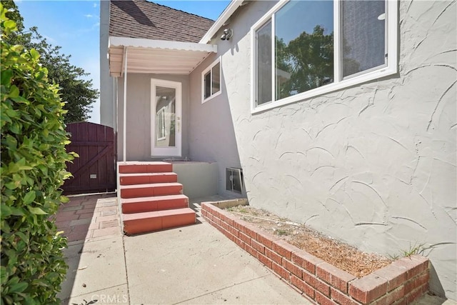 1230 Spazier Ave, Glendale, CA 91201 - view of exterior entry featuring a shingled roof, stucco siding, and a gate