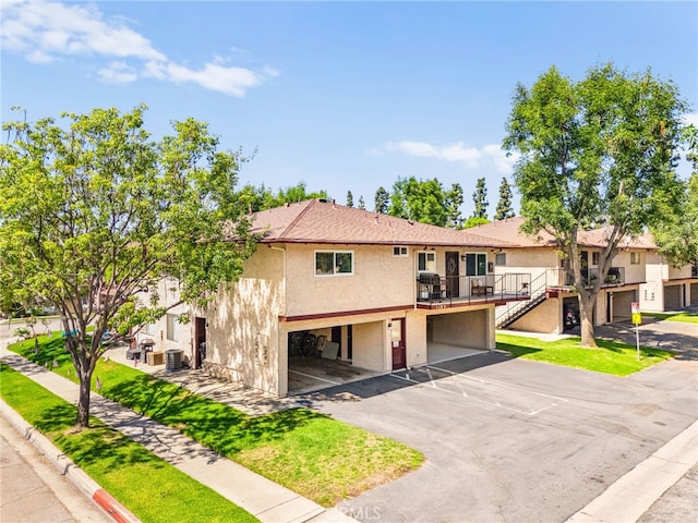 1105 W Calle De La Luna Unit 4, Azusa, CA 91702 - townhome / multi-family property with stucco siding, driveway, an attached garage, a wooden deck, and a front yard