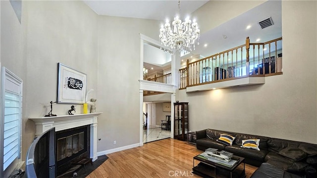 1018 Palm Ave, San Gabriel, CA 91776 - living room featuring a towering ceiling, a chandelier, a fireplace with flush hearth, and wood finished floors
