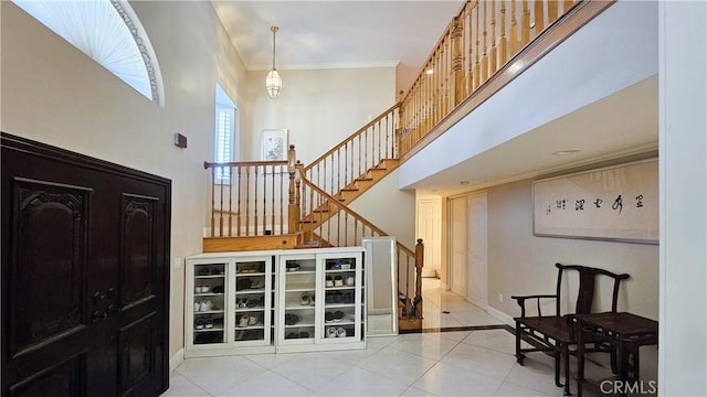 1018 Palm Ave, San Gabriel, CA 91776 - entrance foyer with light tile patterned floors, stairway, a towering ceiling, and ornamental molding