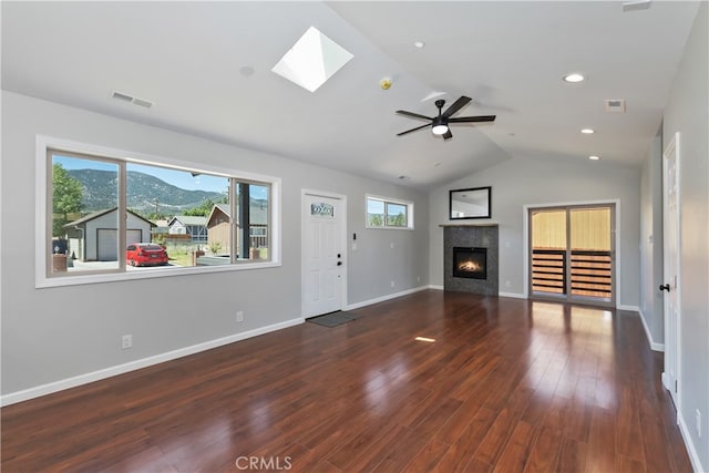 2217 Juniper Ln, Big Bear City, CA 92314 - unfurnished living room featuring a skylight, a tile fireplace, vaulted ceiling, wood finished floors, and a ceiling fan