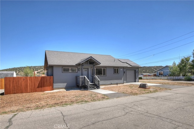 2217 Juniper Ln, Big Bear City, CA 92314 - bungalow-style home with an attached garage, roof mounted solar panels, and driveway