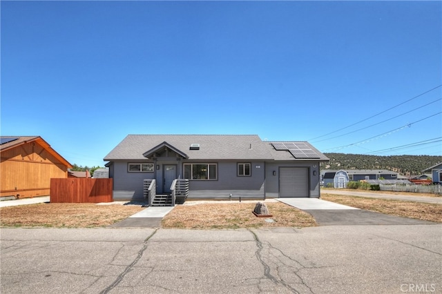 2217 Juniper Ln, Big Bear City, CA 92314 - ranch-style home with an attached garage, solar panels, asphalt driveway, and a shingled roof