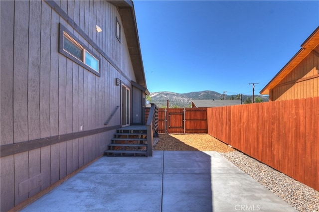 2217 Juniper Ln, Big Bear City, CA 92314 - fenced backyard featuring a mountain view, a gate, and a patio area