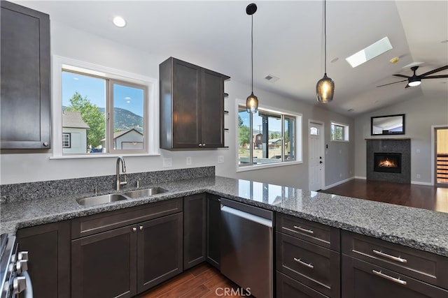 2217 Juniper Ln, Big Bear City, CA 92314 - kitchen with appliances with stainless steel finishes, dark wood-style flooring, a tiled fireplace, lofted ceiling, and stone counters