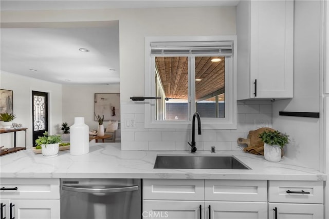 3531 Josie Ave, Long Beach, CA 90808 - kitchen with stainless steel dishwasher, backsplash, white cabinets, and light stone counters