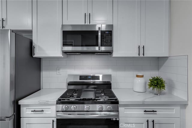 3531 Josie Ave, Long Beach, CA 90808 - kitchen featuring appliances with stainless steel finishes, white cabinets, tasteful backsplash, and light stone countertops