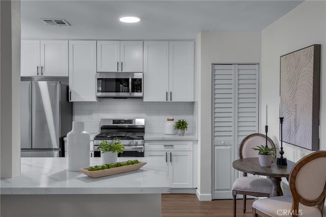3531 Josie Ave, Long Beach, CA 90808 - kitchen with stainless steel appliances, white cabinets, tasteful backsplash, light stone countertops, and recessed lighting